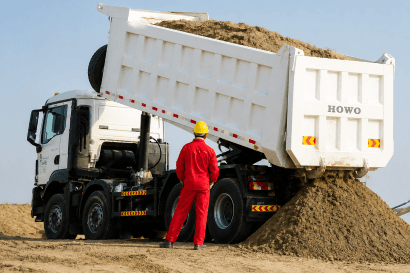 white truck dumping corn